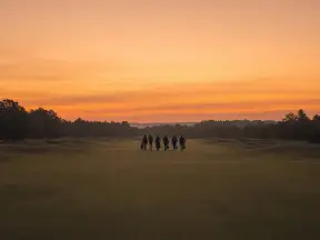해 질 녘 페어웨이를 걸어가는 먼 일행의 실루엣 (연출 이미지)